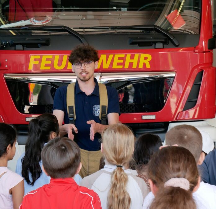 Schüler und Schülerinnen lauschen gespannt den Erläuterungen zum Schlauchwagen Die Brandschutzfrüherziehung für Grundschüler der Regenbogenschule Seelze vermittelt wichtige Sicherheitskenntnisse und praktische Fähigkeiten