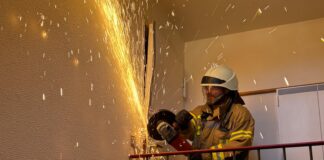 Die Ortsfeuerwehr öffnet Tür für hilflose Person mit Trennschleifer. Der Rettungsdienst musste schnell handeln