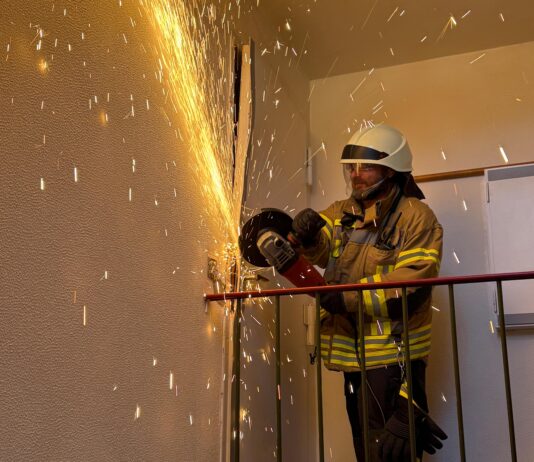 Die Ortsfeuerwehr öffnet Tür für hilflose Person mit Trennschleifer. Der Rettungsdienst musste schnell handeln