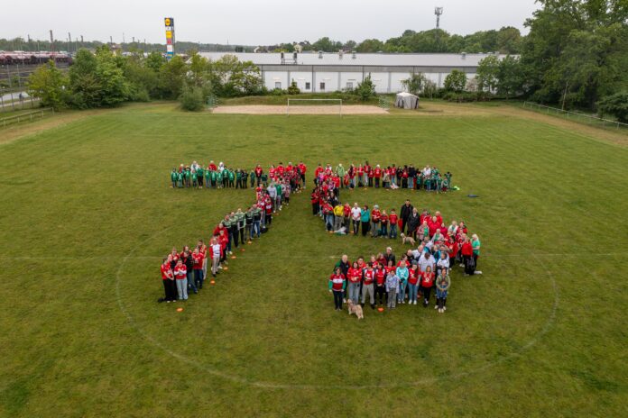 Rund 150 Mitglieder des RSV Seelze kamen am 13. Mai 2026 zum Trikottag auf den Sportplatz, darunter Bürgermeister Alexander Masthoff, Jessika Zimmermann, Thomas Wolff, Dieter Bock und Janet Zoll Trikottag RSV Seelze: Rund 150 Mitglieder kamen in Seelze trotz Regens zum Jubiläumsfoto auf den Sportplatz des Vereins